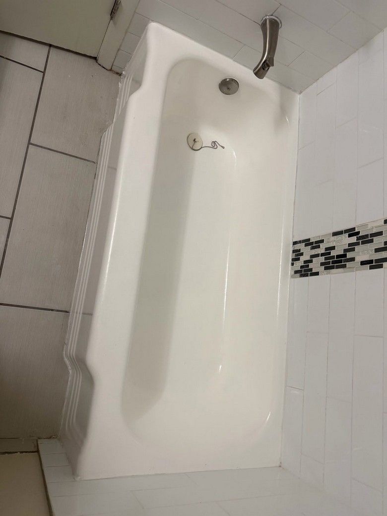 After: the same bathtub refinished with a clean, glossy white surface.
