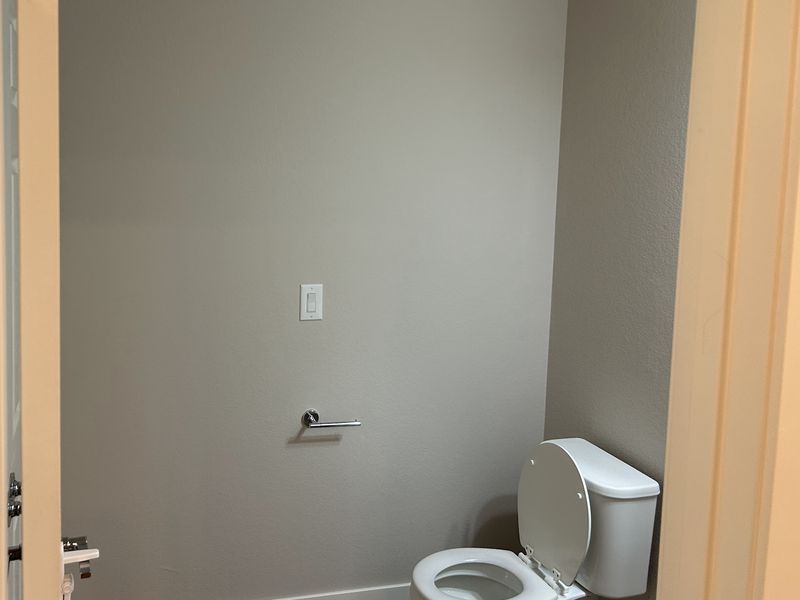 After: the same half bathroom wall, now a light neutral gray.